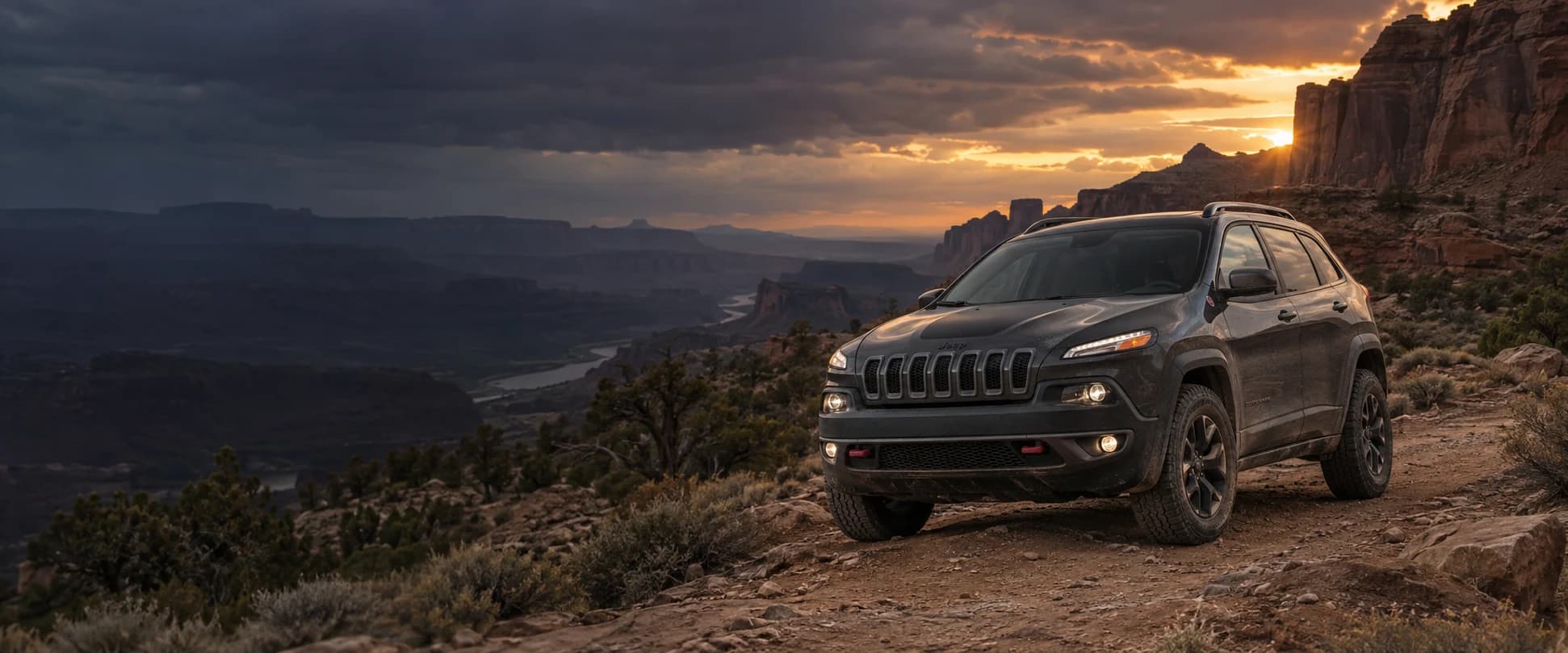 Jeep Cherokee on a rugged desert trail at sunset