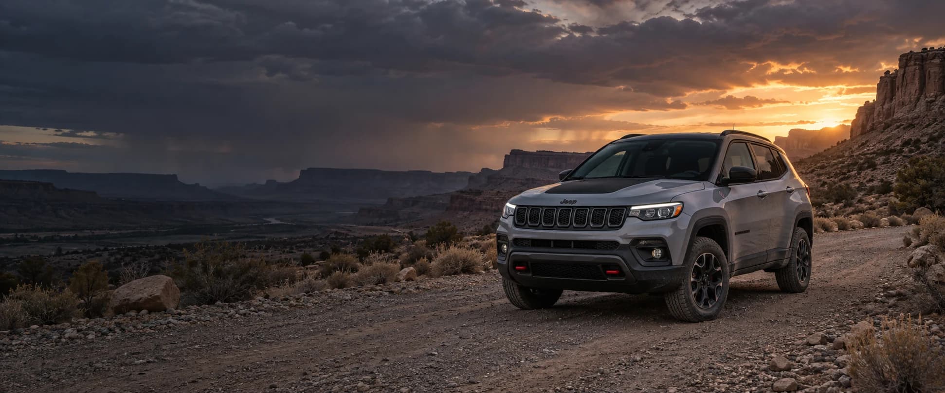 Jeep Compass on a rugged desert trail at sunset