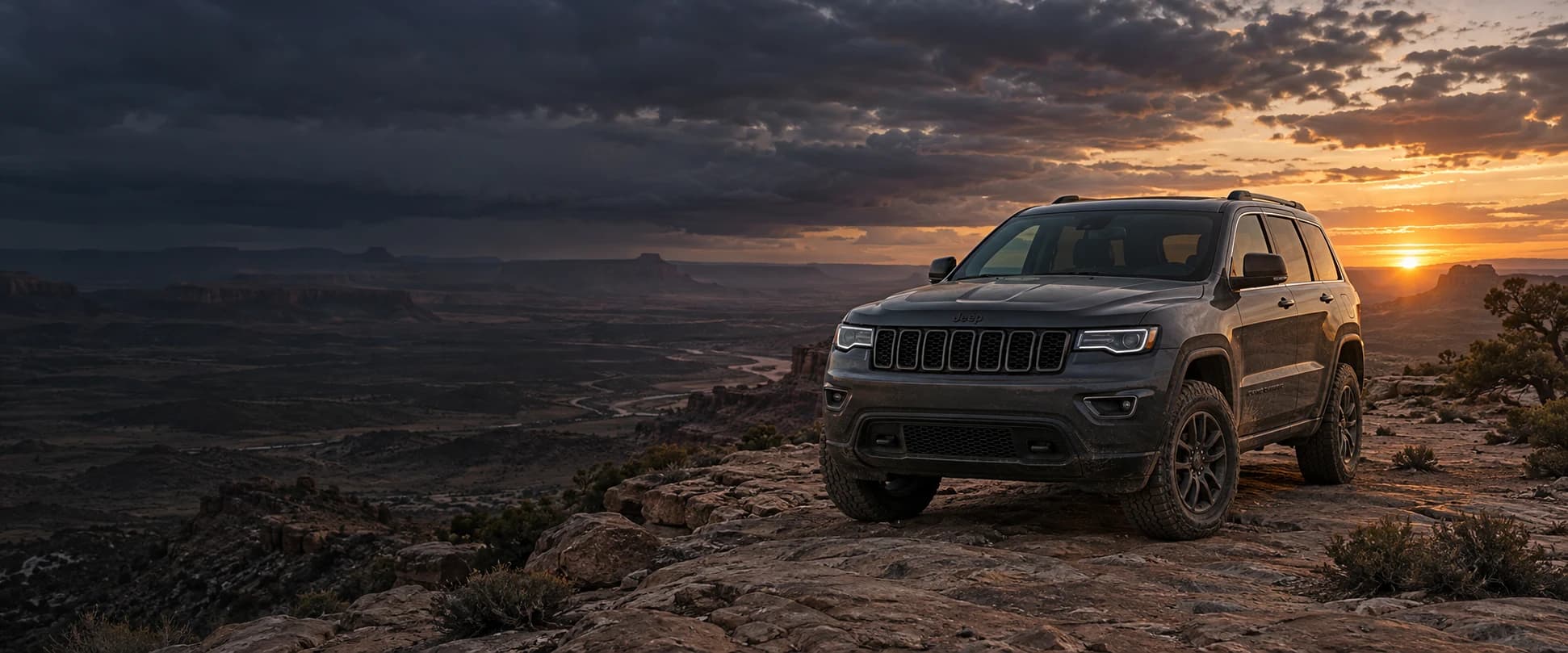 Jeep Grand Cherokee on a rugged desert trail at sunset